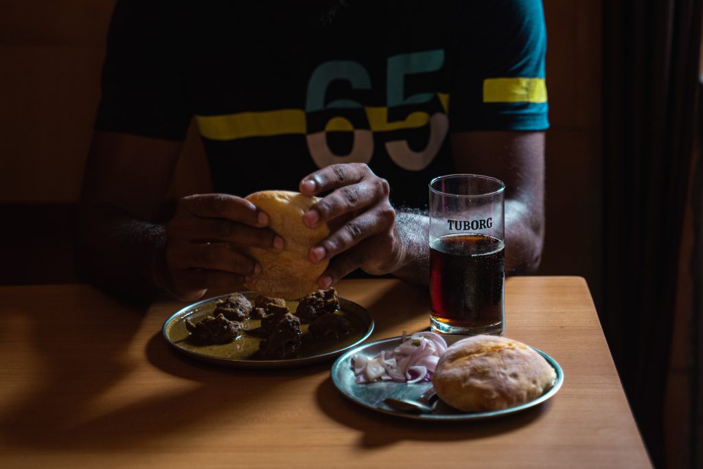 The image shows a slow traveller enjoying cheap Goan food at a local bar in Goa