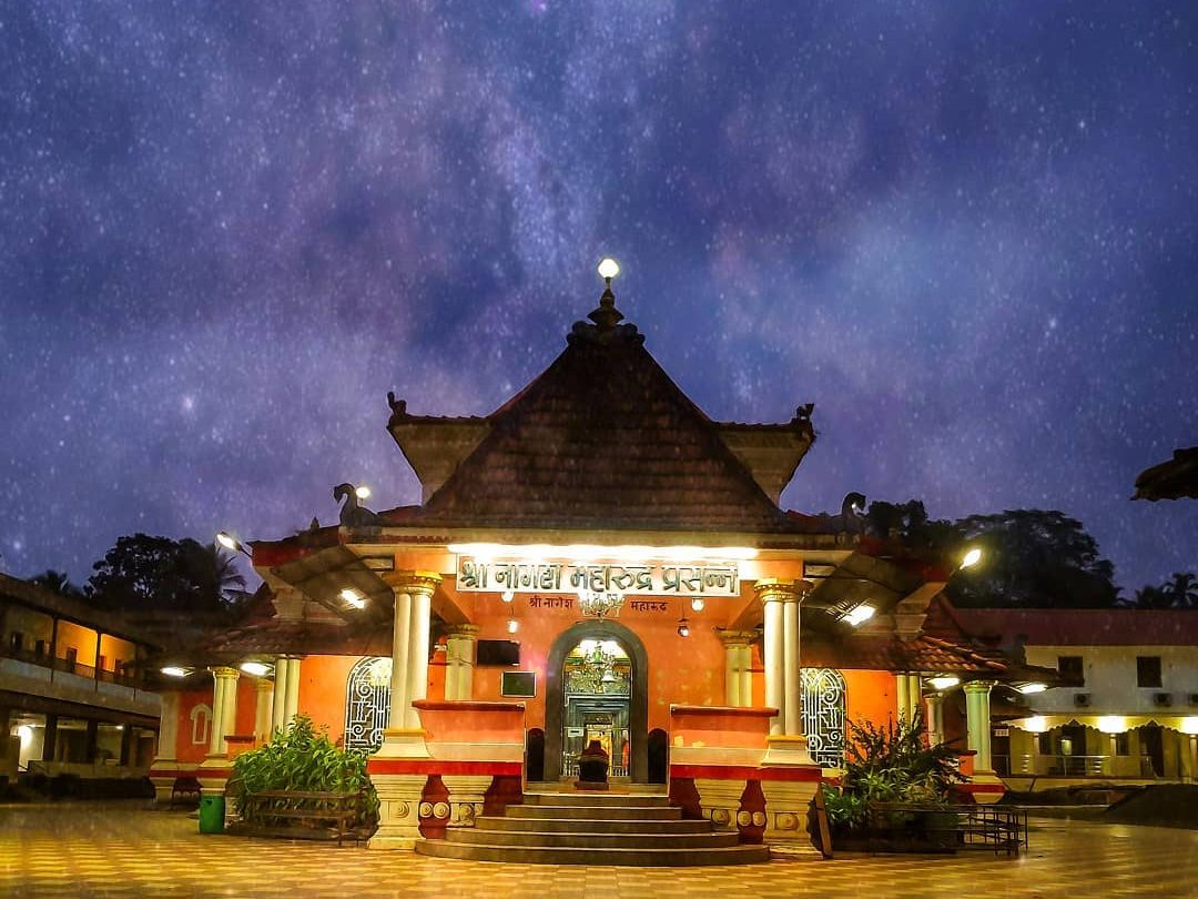 The image shows the Nageshi temple in Goa during nighttime