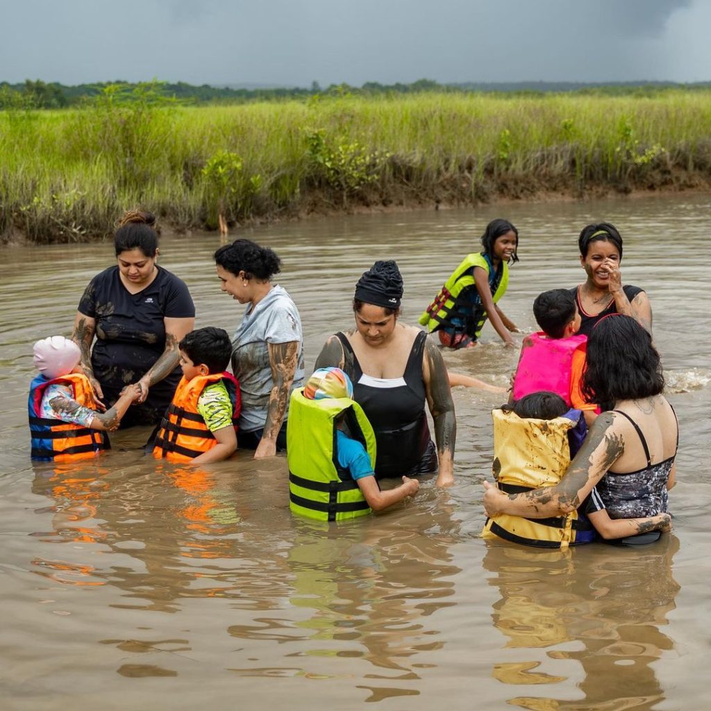 The image shows a family travelling with kids in Goa mud bath in Chorao mud bath in Goa mud bath in Divar