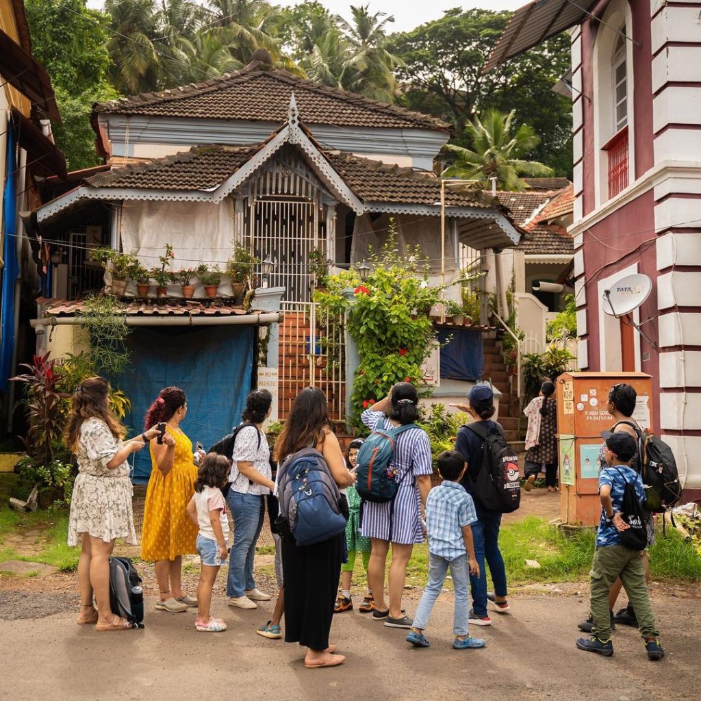 The image shows a family in Goa walking through Latin Quarters in fontainhas