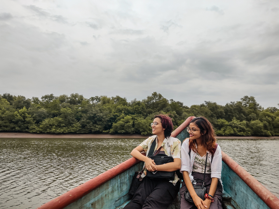 The image shows tourists boating and birdwatching in chorao slow travelling