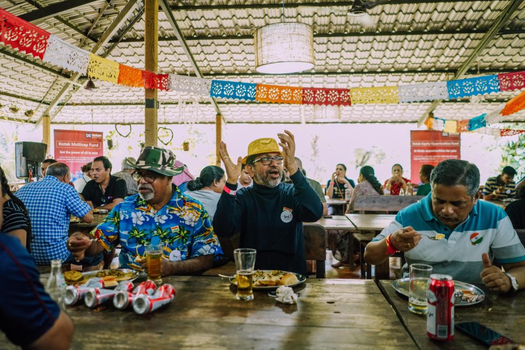 the image shows a group of employees or a family eating together in Goa